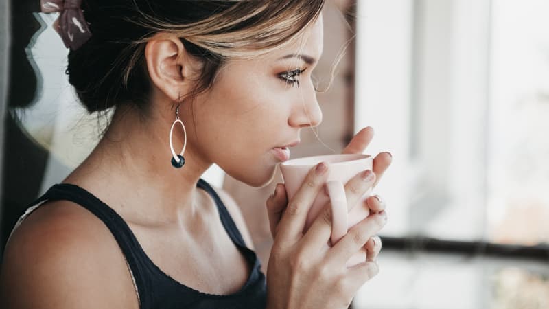 義実家との付き合いに気疲れして、窓辺でひと息つく女性