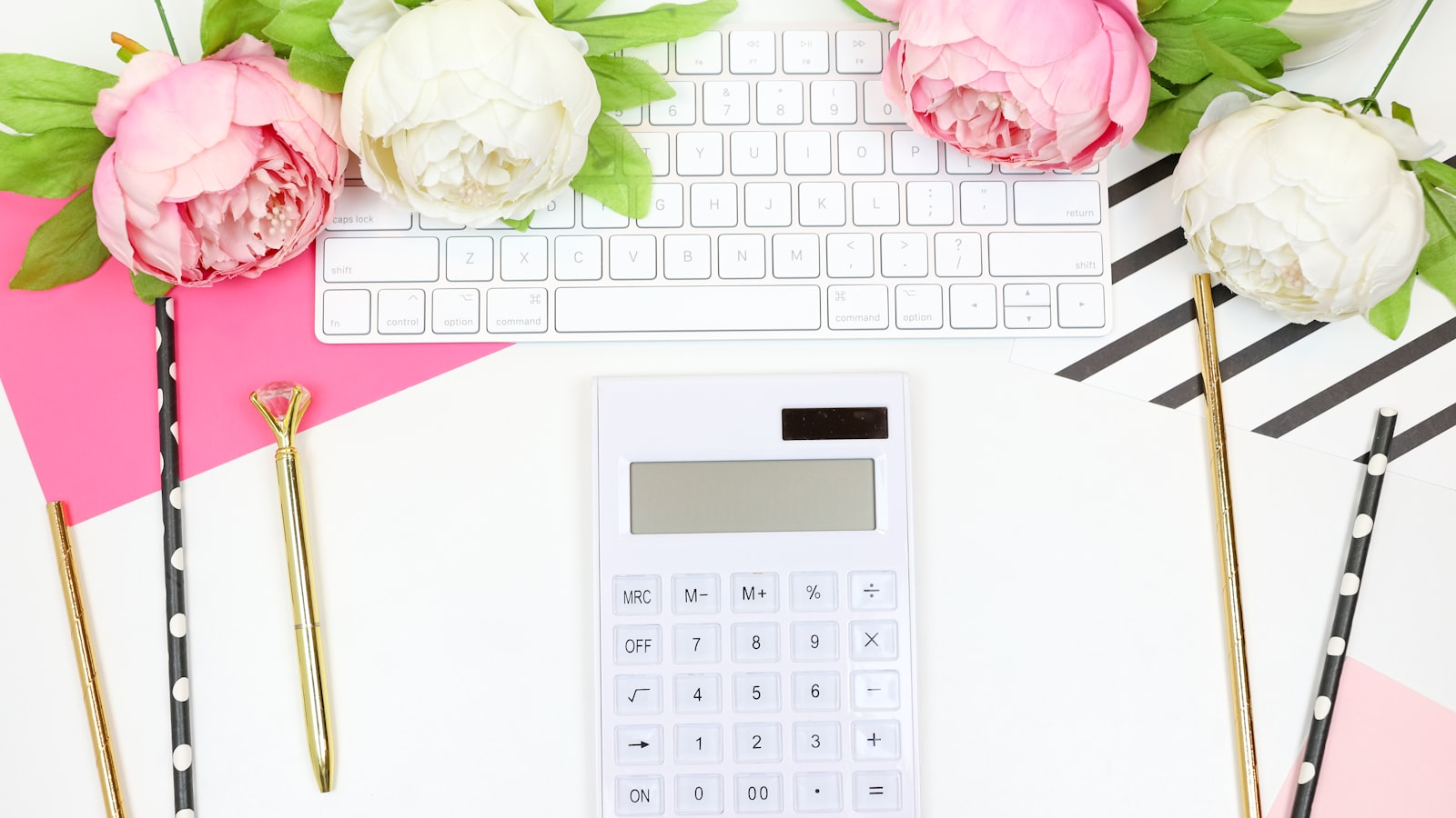 white calculator beside pink rose