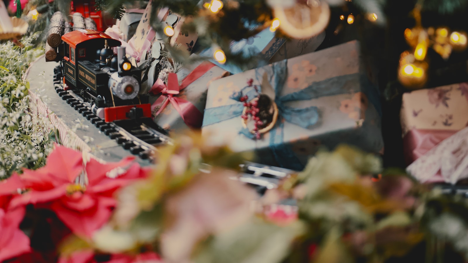 a toy train on a track near a christmas tree