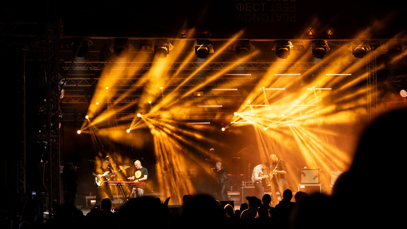 A band performs under golden stage lights.