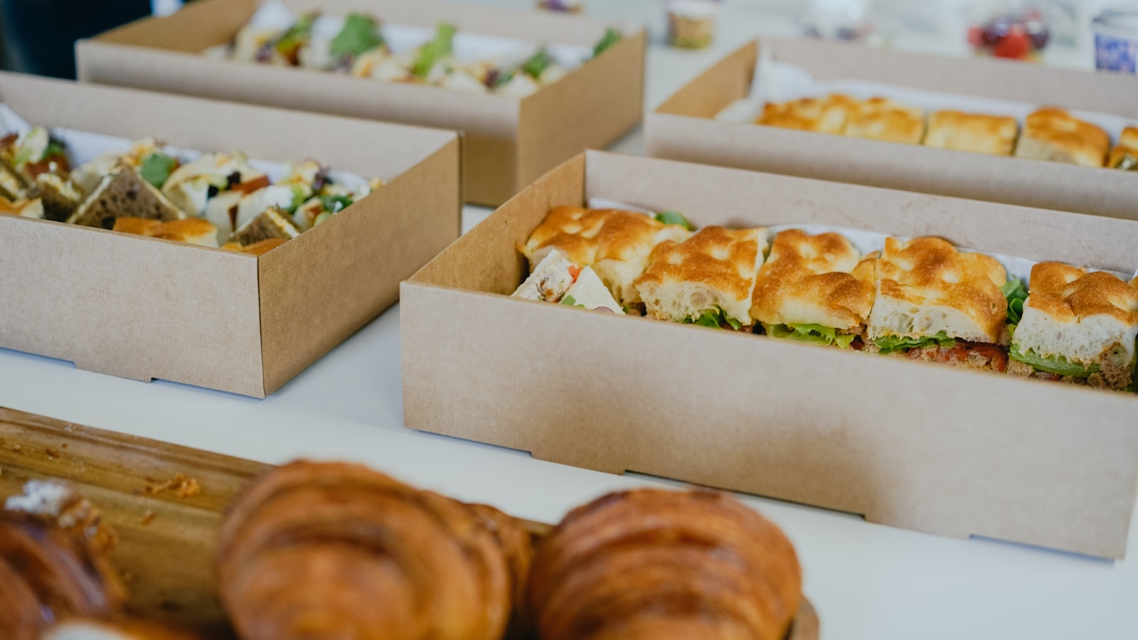 a table topped with boxes of sandwiches and pastries