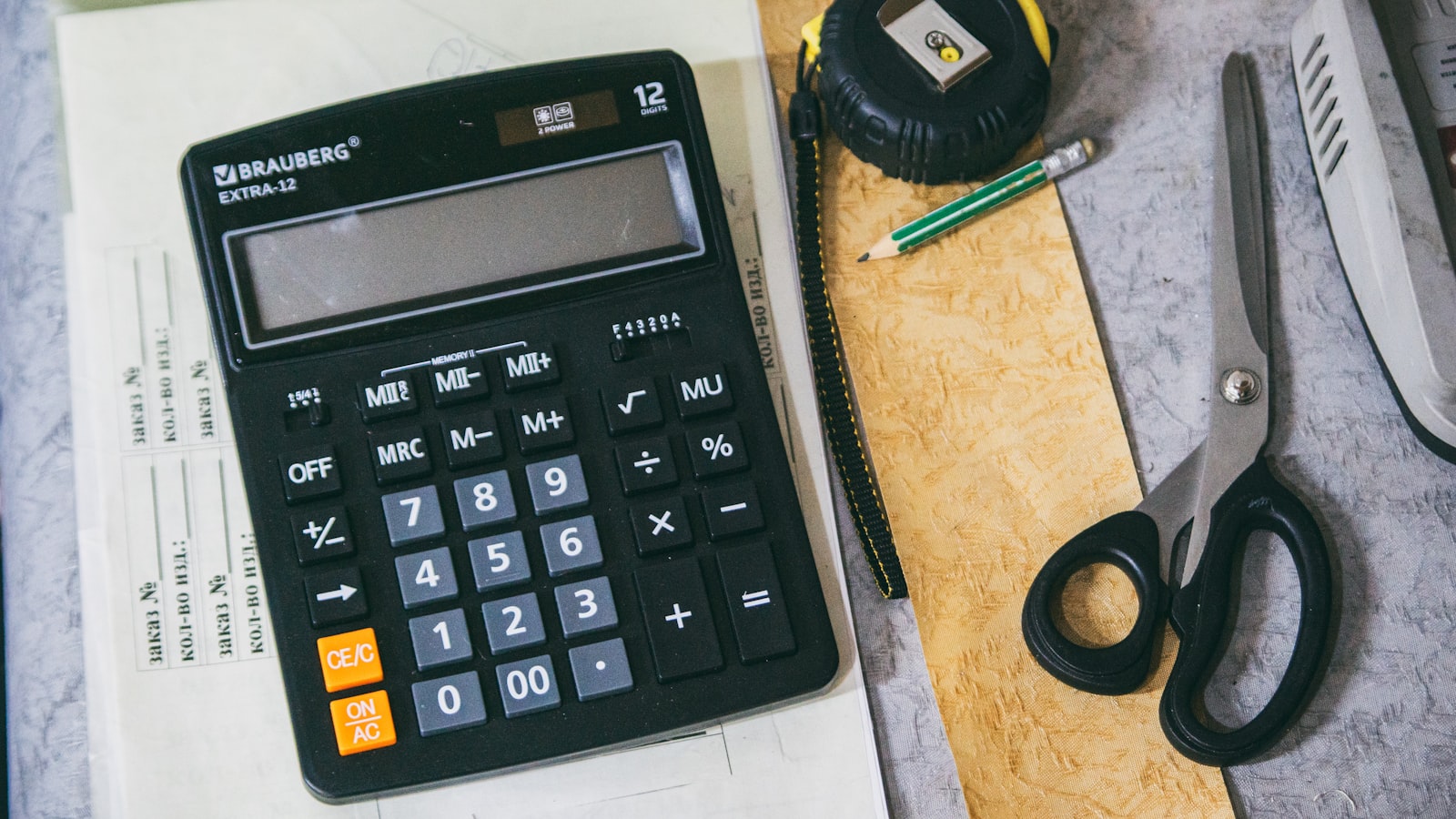Calculator and office supplies on a desk.