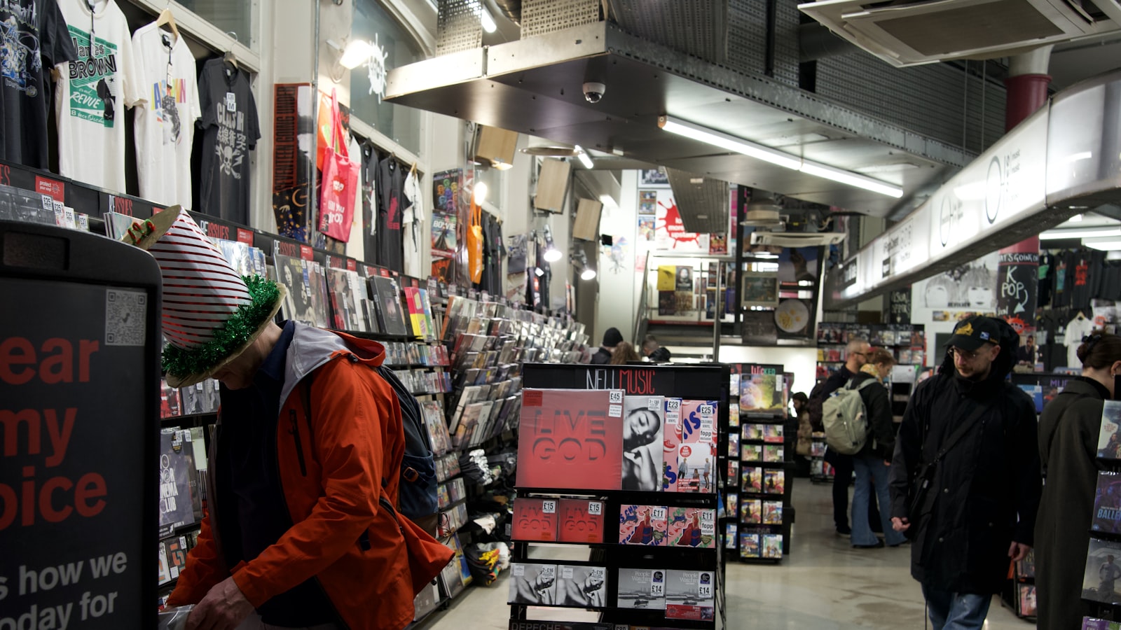 People browsing music and merchandise in a store.