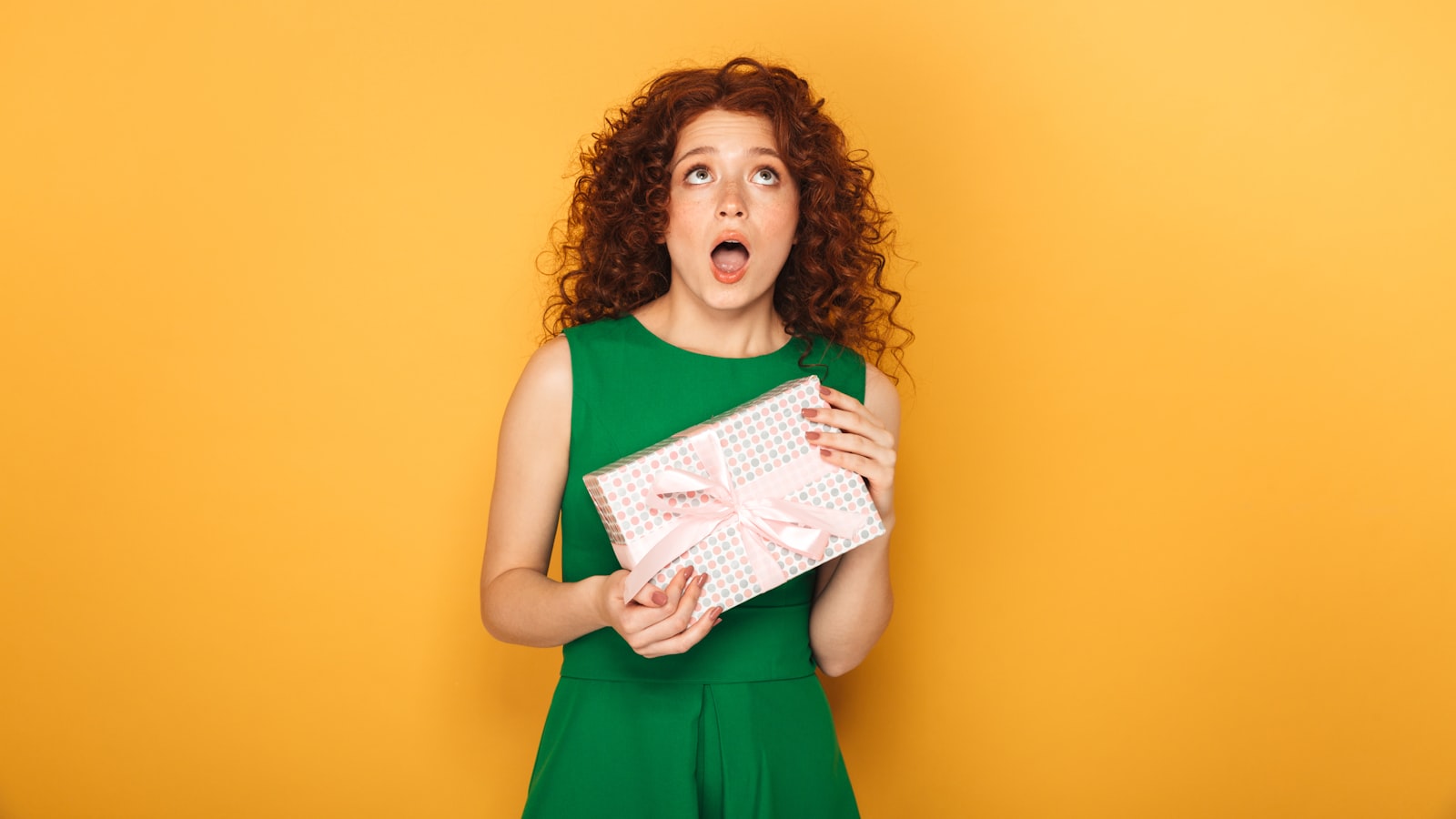 a woman in a green dress holding a present