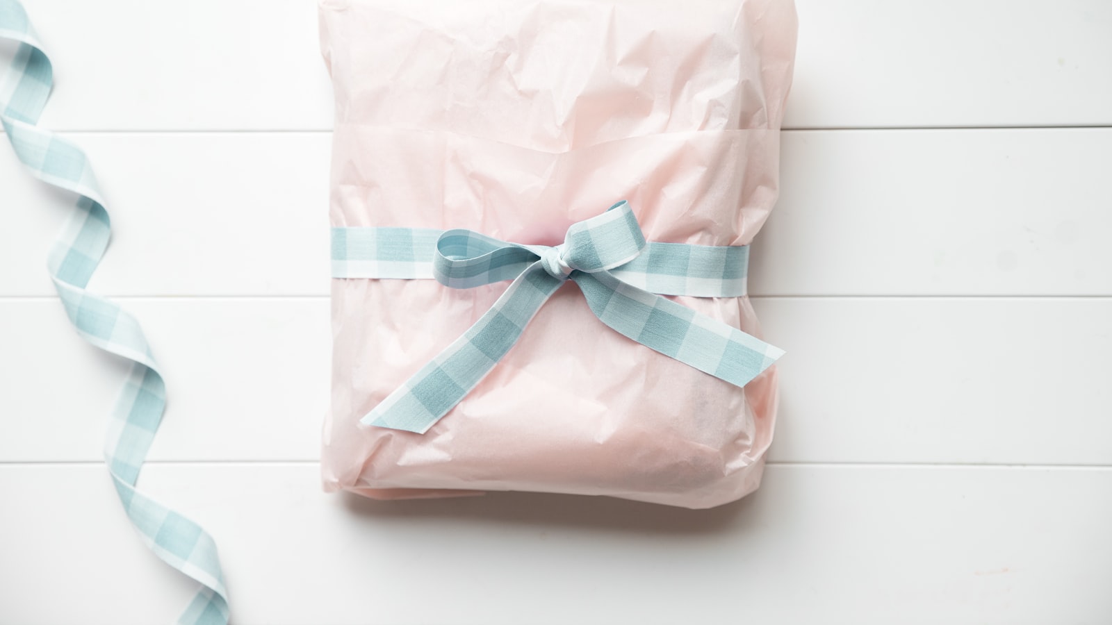 a wrapped present with a blue ribbon on a white background
