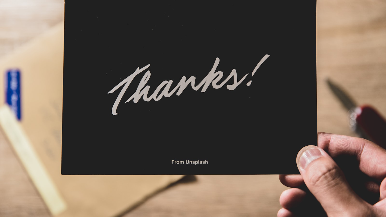 person holding Thanks card
